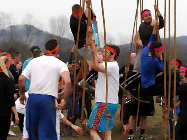men climbing rope obstacle course